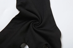 Close-up detail of high-elastic black knitted fabric with fine ribbed texture and soft folds