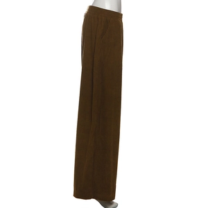 Detail of brown corduroy pants showing vertical ribbed texture and elastic high waist