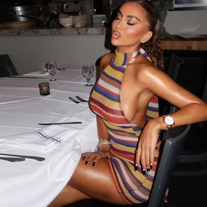 Détail d'une robe en maille à rayures multicolores avec licou et coupe dos nu sexy