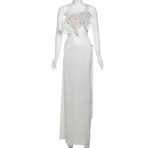 Close-up of elegant white lace crop top with 3D floral details and floor-length maxi skirt