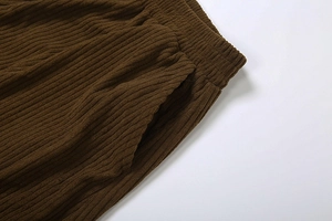 Detail of high waist corduroy trousers showing elastic waistband and side pocket