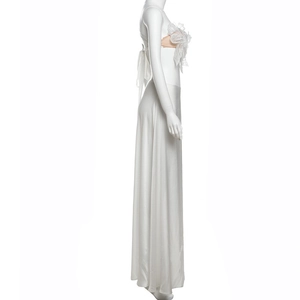 Detail of the oversized white lace bow decoration on a backless satin maxi dress set