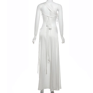 Detail of white backless dress featuring elegant lace trim and long ribbon ties