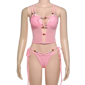 Detail of pink three-piece bikini set featuring vibrant beadwork and mesh fabric accents