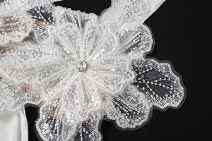 Close-up of handmade 3D sequin flower patch with silver beads and center rhinestone
