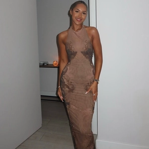 Detail view of bodycon halter maxi dress with black lace pattern and sleek brown fabric