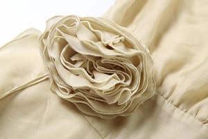 Détail macro d'appliques florales 3D faites main sur mini robe couleur champagne