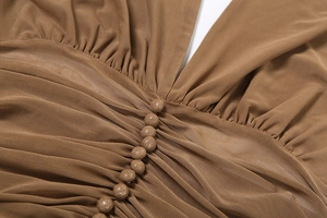 Macro shot of brown mesh fabric with pleated texture and fabric-covered buttons on the top