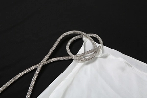 Detail of white satin dress featuring luxury rhinestone encrusted spaghetti straps