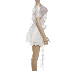 Détail d'une robe blanche en mousseline à épaules dénudées avec volants et laçage au dos