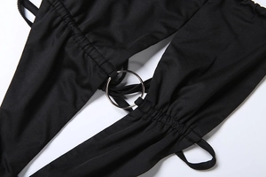 Detail of black hollow-out romper featuring metallic silver ring and ruched drawstring design