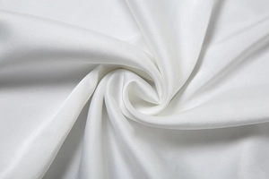 Detailed close-up of high-quality white satin fabric texture with soft silk luster