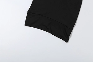 Vista dettagliata della trama in maglia nera e delle cuciture rifinite sull'orlo dell'abito