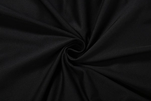 Dettaglio del tessuto nero testurizzato con eleganti pieghe centrali e drappeggio