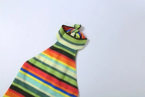 Détail de robe dos nu en tricot rayé coloré avec tissu texturé et nœud au col