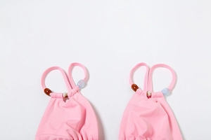 Detail of pink bikini top straps featuring colorful translucent bohemian beads