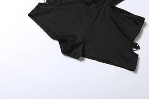 Detail of black cutout jumpsuit featuring silver metal ring connector and stitched edges