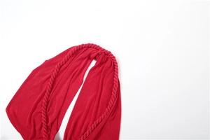 Close-up of vibrant red dress featuring a chunky braided halter neckline and knit texture