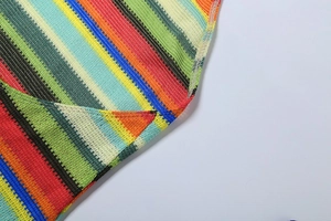 Gros plan sur la texture du tissu en maille rayé multicolore avec détails de couture