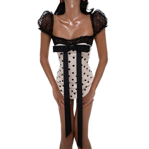 Detail of retro polka dot mini dress with mesh lace sleeves and large black satin bow