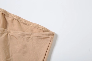 Gros plan sur la couture fine à double aiguille et la texture de la robe fleurie beige