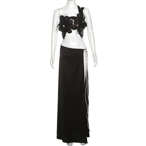 Detail of 3D sequin flower top and high slit satin skirt with silver chain accents