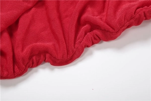 Close-up of red ribbed knit fabric detail featuring elastic ruched edges and soft texture