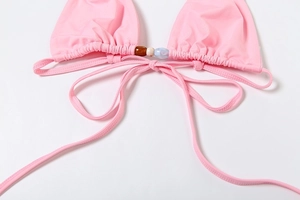 Detail of pink bikini top with ruched triangle cups and decorative marble texture beads
