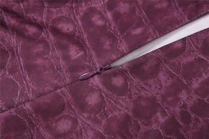 Dettaglio del tessuto con stampa animalier viola scuro e cerniera a scomparsa