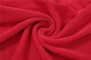 Macro shot of the vibrant red ribbed knit fabric with soft texture and detailed vertical lines