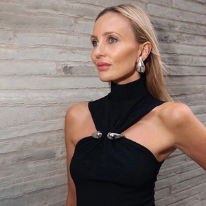 Detail of black turtleneck crop top featuring silver teardrop metal buckle decorations