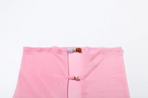 Detail of pink mesh fabric with colorful bead accents and translucent texture on a bikini set