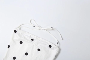 Detail of polka dot camisole with adjustable spaghetti straps and bow tie design