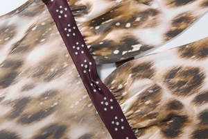 Gros plan sur tissu léopard avec bordure en satin violet et détails de fleurs argentées