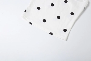Detailed view of white polka dot fabric texture with high quality stitching on the hem