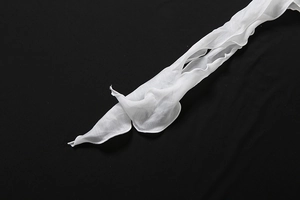 Détail du tissu en mousseline blanche avec volants et couture de bordure précise