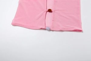 Detailed macro view of pink sheer mesh fabric texture with amber and blue bead accents