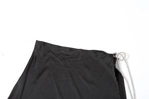 Detailed macro of smooth black satin fabric with shimmering rhinestone chain trim