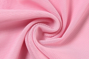 Close-up of breathable pink mesh fabric with honeycomb texture and soft swirl pattern