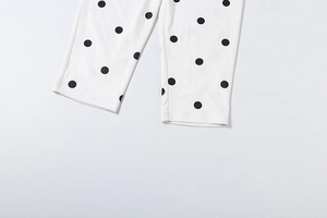Detailed view of the double-stitched hem on high-waist polka dot pants with black spots