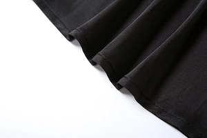 Detail of high-quality double stitching and woven texture on a black long skirt hem