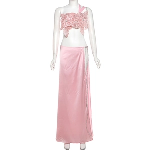 Detail of pink floral sequin top and side slit satin maxi skirt on a white mannequin