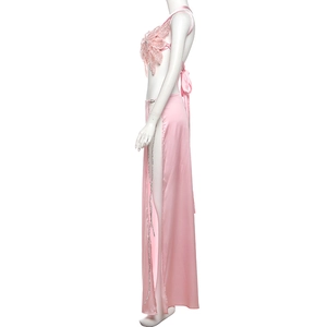 Detail of pink backless sequin top with lace flowers and high-slit satin skirt
