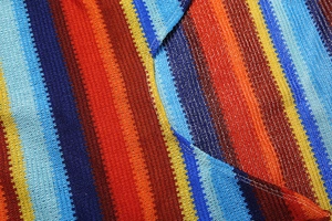 Gros plan de rayures verticales multicolores sur le tissu d'une robe sexy en tricot