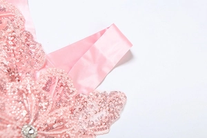Detail of pink sequins and beaded floral pattern with rhinestones on a satin strap