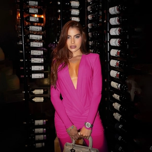 Detail of fuchsia deep V-neck slim jumpsuit with subtle metallic accessories in cellar