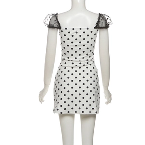 Detail of square neckline with black lace trim and polka dot mesh puff sleeves