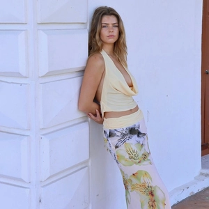 Detail of light yellow halter top with backless design and floral print maxi skirt