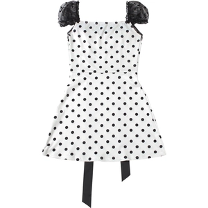 Detail of cute polka dot dress featuring mesh puff sleeves and black silk ribbon hem
