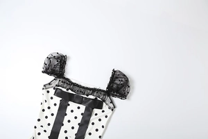 Detailed view of polka dot dress featuring mesh puff sleeves and a large satin bow